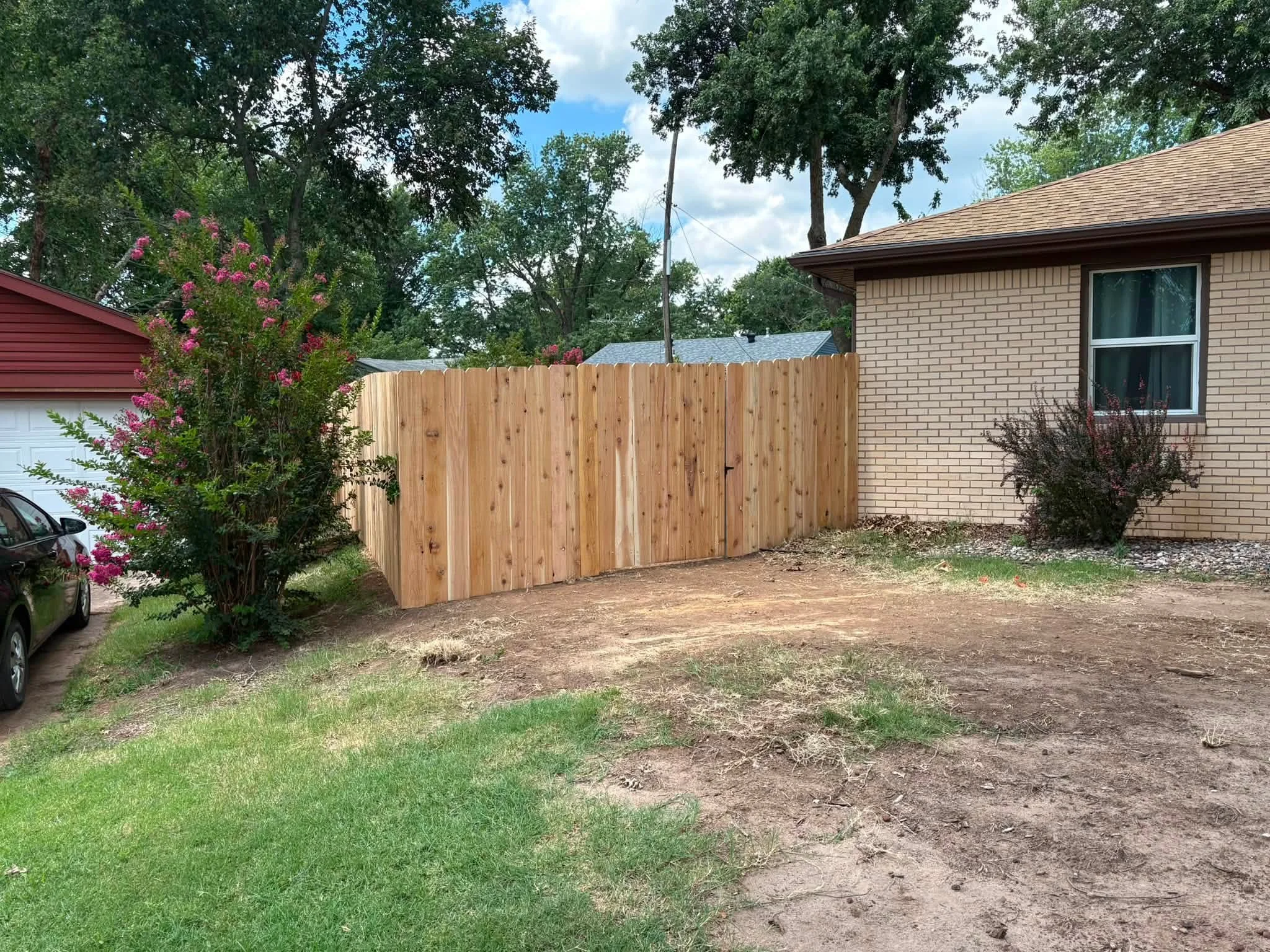 Newly installed cedar vertical board privacy fence along residential property