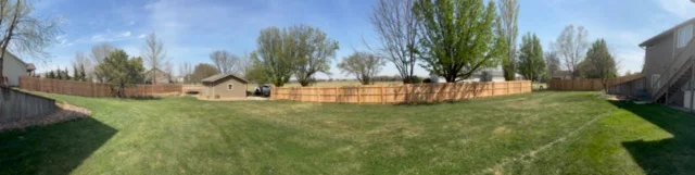 Newly installed brick fence with stacked clay brick construction and mortar joints along residential property