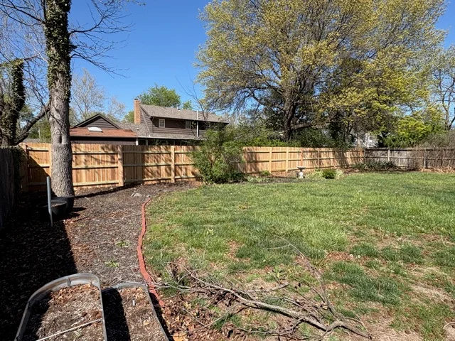 Horizontal cedar privacy fence with gate installed around residential backyard