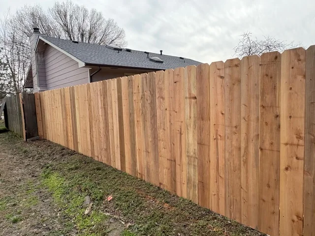 Cedar wood privacy fence with vertical boards and post construction along residential property