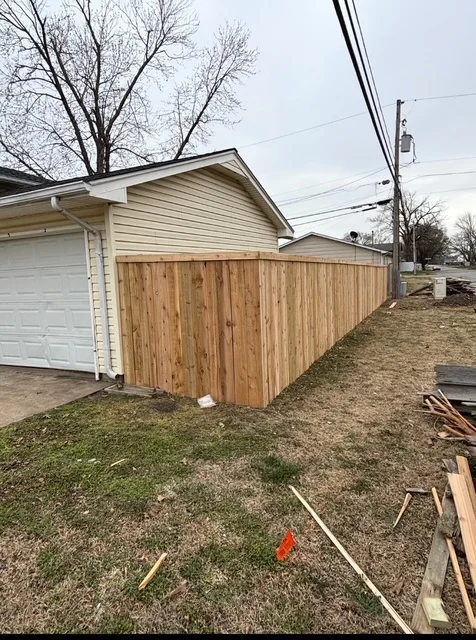 Newly installed vertical cedar privacy fence with natural wood finish along residential property