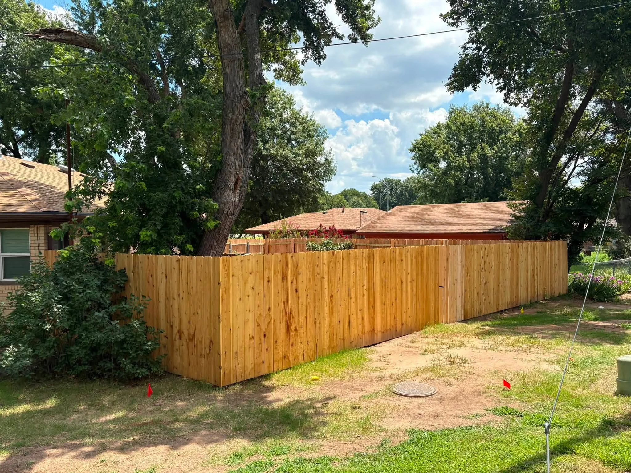 Cedar vertical board privacy fence with natural wood finish in residential backyard