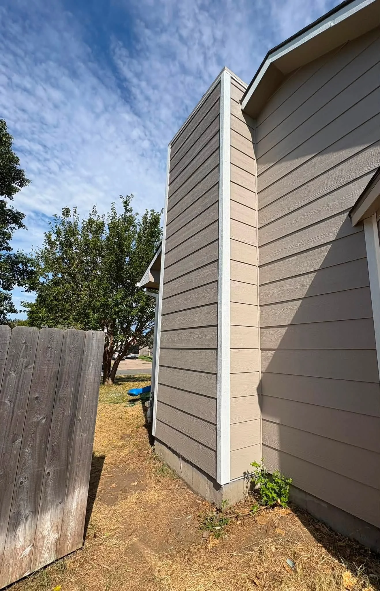 Horizontal fiber cement siding with white corner trim on residential home exterior