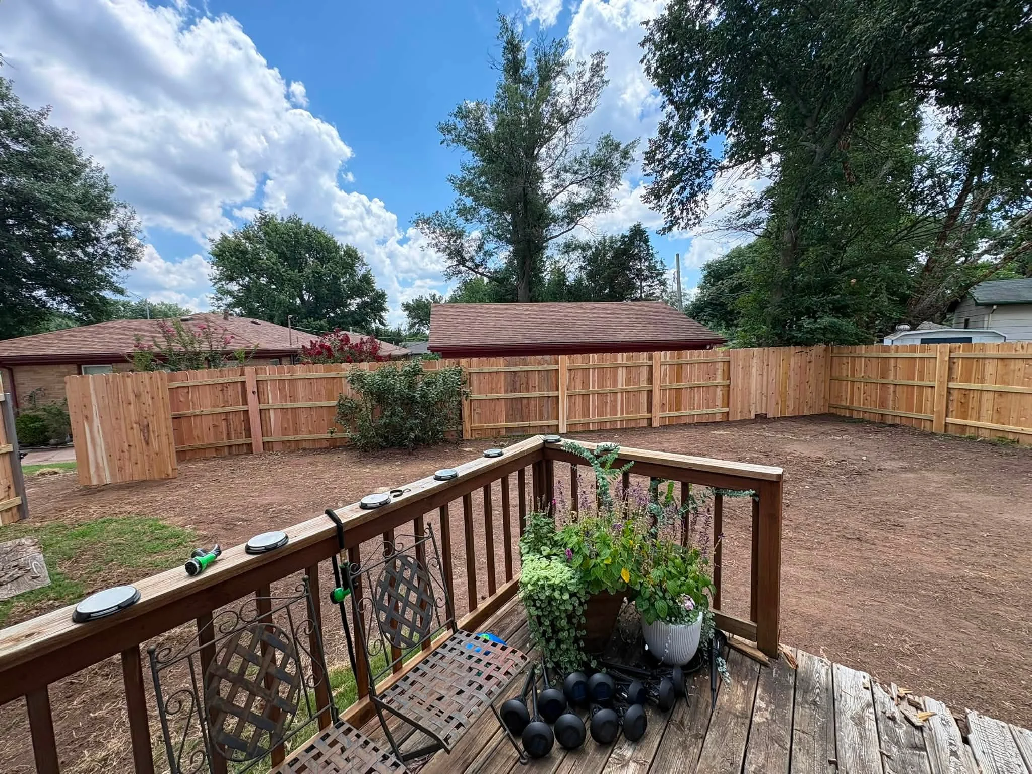 Cedar privacy fence with lattice gates and wooden deck railing in residential backyard