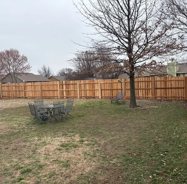 Newly installed wood privacy fence with vertical boards around residential backyard