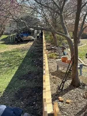 Newly installed wooden fence with treated lumber posts and rails along residential property