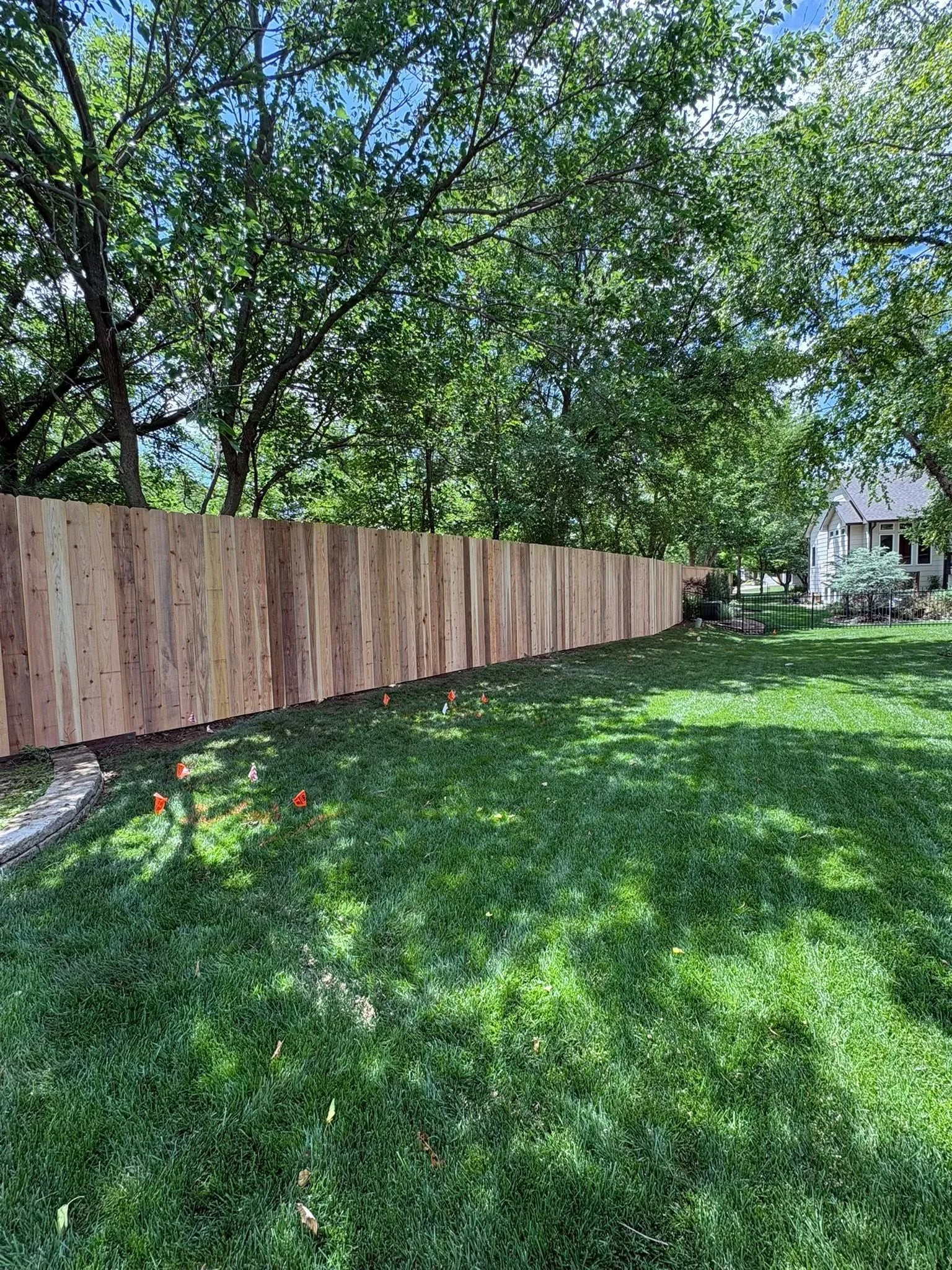 Close-up of fence post installation in Kansas clay soil with reinforced concrete foundation