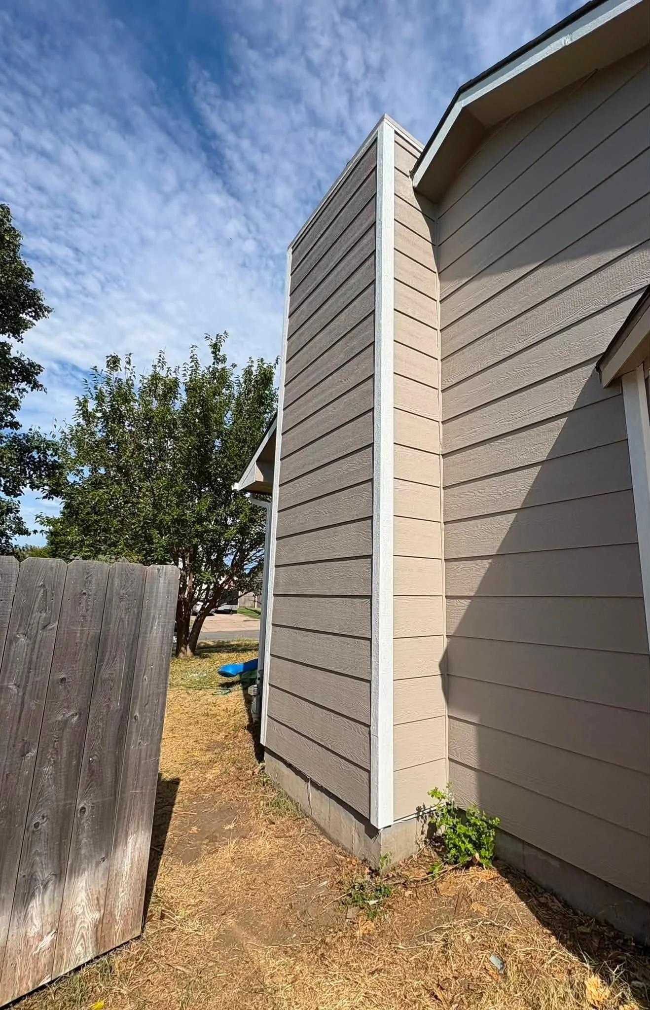 Freshly installed siding on a single-family home in Maize, Kansas, with clean panel lines and finished trim around windows and corners. The completed exterior shows uniform coverage across all walls with no gaps or exposed edges.