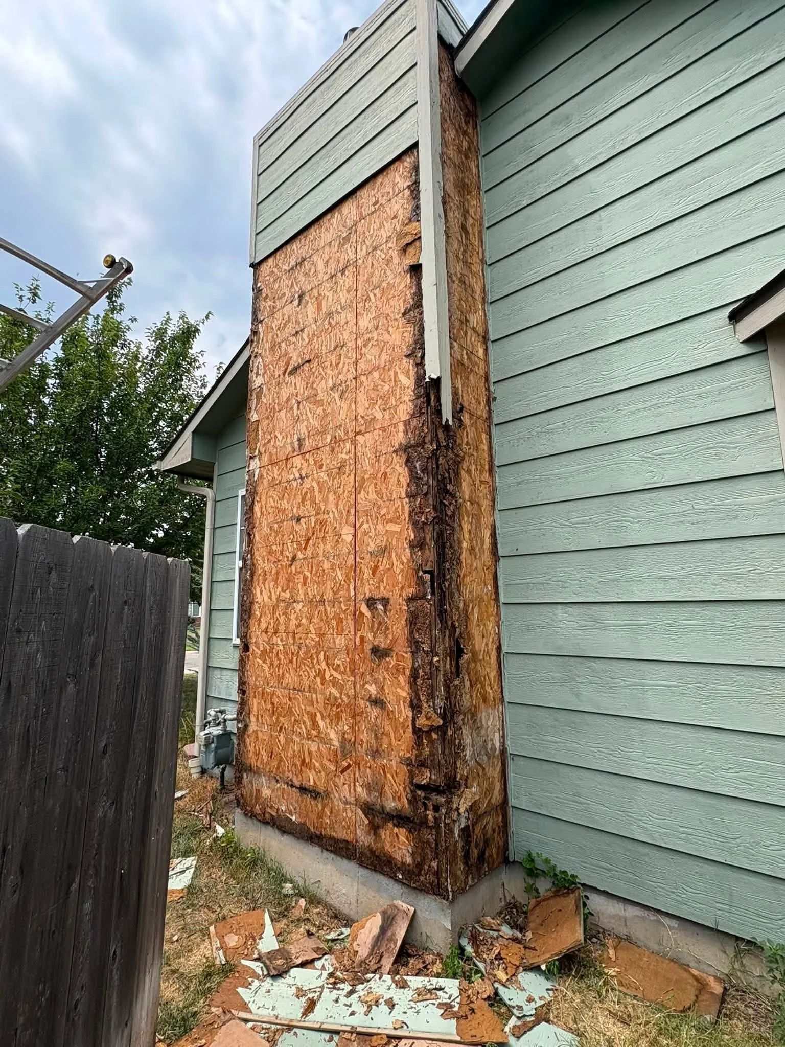 Close-up view of repaired exterior siding on a residential home in Maize, Kansas, showing patched panels and sealed seams after hail and wind damage. The repaired section blends with the surrounding exterior wall on a single-story home.